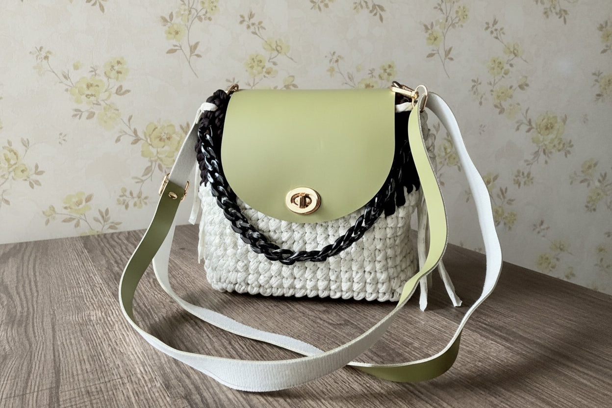 Green handbag with a textured white base and black chain detail